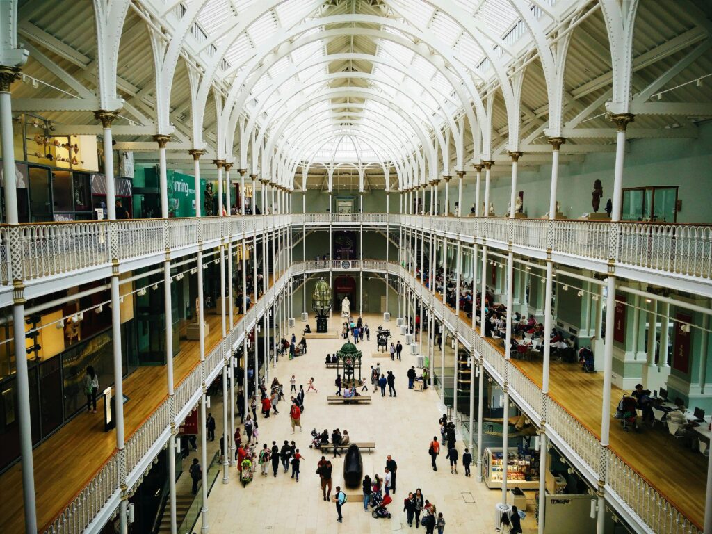 Interior view of the National Museum of Scotland's grand hall with visitors exploring exhibits.